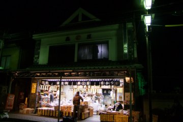<p>A mom-and-pop shop lit up at night</p>