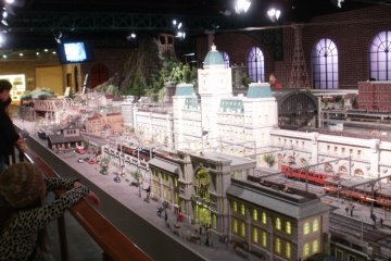 Large diorama of trains with city and mountains.