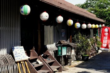 <p>Paper lanterns decorate a casual riverside restaurant</p>