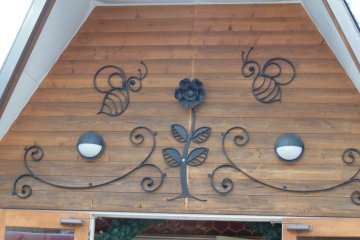 <p>Bees and a flower decorate the entrance.</p>
