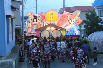 <p>The tail end of one of the float's processions. Taiko drums attached to the back of the float, with people dancing or just chatting behind.&nbsp;</p>