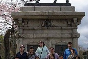 International visitors from Beaver Village, Alaska pose with GOZAIN&nbsp;volunteer guides in front of the Date Masamune statue on Aobayama.