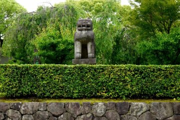 Un lion de pierre et des haies droites