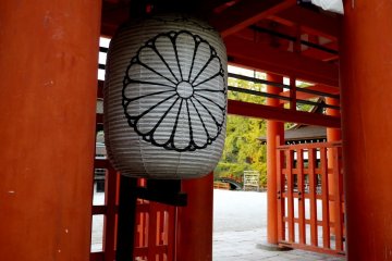 <p>Large paper lanterns with the Imperial chrysanthemum motif hang within the gate</p>