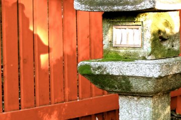 <p>Reflection of stone lantern near the entrance to the shrine</p>