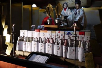 <p>Float puppets on display at street level, and festival offerings of sake</p>