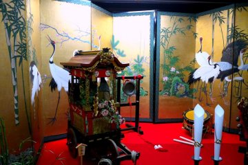 <p>A model of one of the floats in front of a gorgeous screen</p>