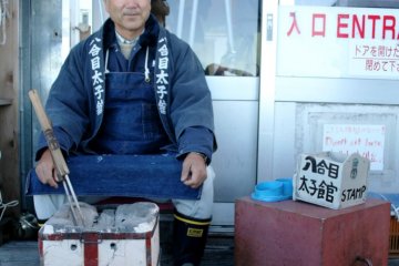 A guy with a hot iron in front of the lodge at the 8th station