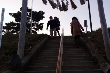 <p>The approach to the shrine on the man-made hill. That small stone poking out of the ground on the left was part of the original tori gate.&nbsp;</p>