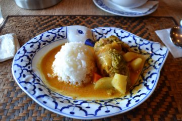 A tasty main dish of rolled cabbage, vegetables, and rice in a delicious curry sauce