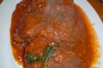 <p>Chef's special: tender marinated pork baked in a tomato sauce. We used plain pizza bread to clean the plate. I say the pizza was filling BUT admittedly, we indulged in other dishes such as this one</p>