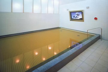 <p>A view of the onsen with the big screen TV to enjoy while you soak in the natural hot waters.</p>