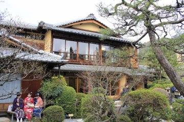 <p>A 2 story Japanese house with glass doors, which allow you to admire the beauty of a Japanese garden. The girls in kimono are waiting to get in.</p>
