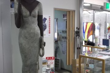 <p>This woman is standing serenely near the entrance</p>