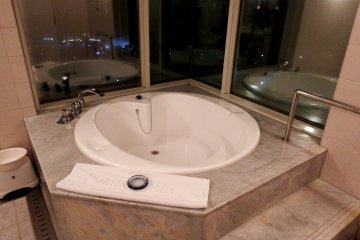 <p>Heart-shaped bathtub with glass window overlooking the lit-up Great Akashi Strait Bridge</p>