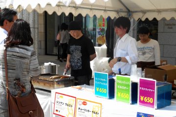 <p>Food stand selling German food in front of the Naruto German House</p>