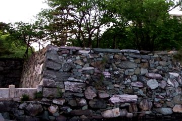 <p>Colorful stone wall, with pink, blue, green-like color stones</p>