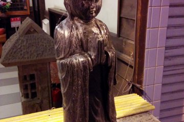 <p>Pouring water over Kannon, the goddess of mercy, is a ritual observed by visitors to this small prayer area setup where a storefront would usually be.&nbsp;</p>