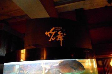 <p>Signage of 'Take-no Mai (Bamboo Dance)' and swimming fish in the tank</p>