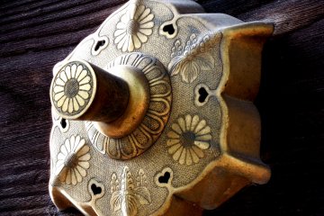 <p>Close-up of one of the gold decorations. Crests of Japanese Imperial family (chrysanthemum) and Toyotomi Clan (Paulownia of 5-7) are engraved</p>