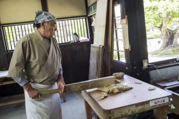 Sang master, secara harfiah memukuli kulit kayu murbei menjadi bubur setelah dibersihkan