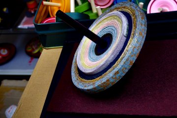 <p>Beautiful spinning top made of Nishijin Kimono Sash fabric. I asked if it's made by 'leftovers' of Kimono Sash, as Nishijin Sash is very expensive, but according to the Maestro, the material was custom-made just for this Koma, the spinning top!</p>