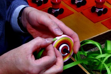 <p>This is how you make Kyo Koma (Kyoto Spinning Tops). How tight/loose you wind it is the key to success, the Maestro says. When the balance is wrong, the top won't spin at all!</p>