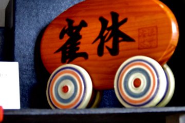 <p>Shop name on wooden plaque, 'Jackyu', which means a sparrows' resting place</p>