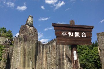 <p>A lone visitor stands under the Peace Kannon</p>