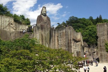 <p>A backdrop of sky blue and forest green frame the Peace Kannon</p>