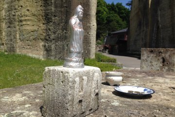 <p>Dedication statue and donation plate below the Peace Kannon</p>
