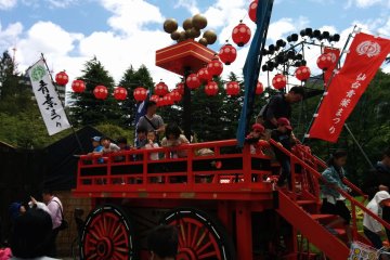 An empty float is swarmed by children ordered by their parents to pose for a souvenir picture.