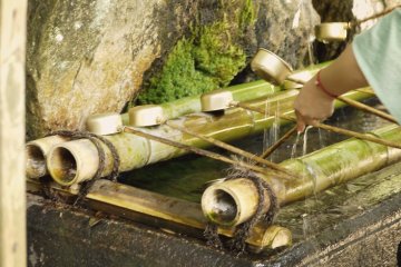 <p>L'eau avec laquelle les visiteurs se lavent avant de p&eacute;n&eacute;trer dans le sanctuaire. Le processus est tr&egrave;s codifi&eacute;; apr&egrave;s avoir r&eacute;cup&eacute;r&eacute; de l'eau &laquo;&nbsp;tombante&nbsp;&raquo; dans une cuill&egrave;re, il faut s'humecter la main gauche, puis la droite, puis r&eacute;cup&eacute;rer de l'eau au creux de sa paume qu'on porte ensuite &agrave; sa bouche avant de la recracher dans le foss&eacute;.</p>