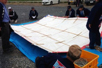<p>The Kesennuma&nbsp;enthusiasts prepare one of their large kites for flight</p>