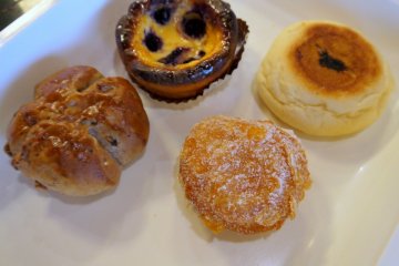 <p>Walnut bread roll, blueberry custard tart, special Nagano bread with greens, and the best cream donut I've ever eaten (it had been dipped in crunchy cornflaked before cooking)</p>