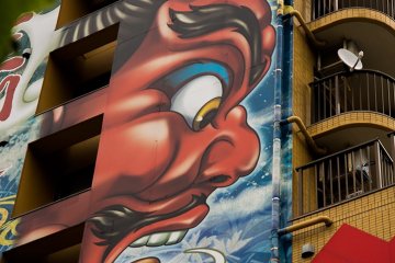 <p>A graffiti building overlooks the temple&nbsp;</p>