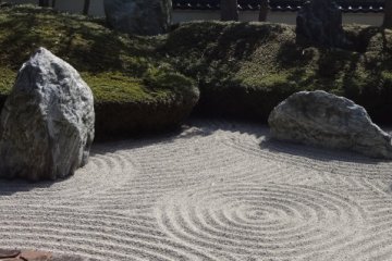 <p>There are six large stones placed among the fine gravel designs. Each stone symbolizes one of the three main Buddhas and a well-known priest from the Kamakura Period&mdash;including Ryochu.</p>