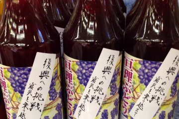 <p>Bottles of grape juice from Yamamoto Town with "Challenge to the recovery" labels</p>