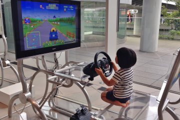 <p>Spotted this cute kid trying a driving simulator in one corner of the Nissan Gallery. There were a few terminals for kids to enjoy. Professional class driving simulators by game maker Polyphony Digital (Gran Turismo) also are set up in the gallery.&nbsp;</p>
