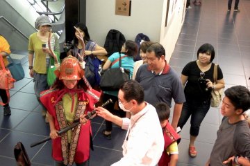 Salah satu pengunjung mencoba kostum samurai. Dia terlihat sangat senang dan puas! Oh iya, ini adalah pelindung samurai Sanada Yukimura.