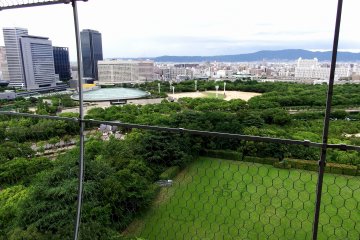 Pemandangan dari atas menara utama. Arsitektur berbentuk bundar di kiri atas adalah Aula Kastil Osaka.