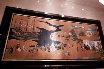 <p>Overview of the ceramic art mural, 'Namban Screen' displayed on the wall in the Westin Osaka's lobby</p>