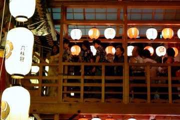 <p>A bridge between an upper floor and one of the tall Gion floats</p>