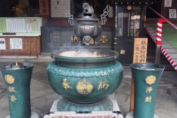 <p>Burning incense outside a shrine</p>