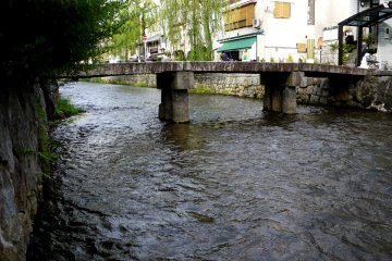 <p>Jembatan sempit batu melintasi Shirakawa yang mengalir antara Sanjo dan Shijo</p>