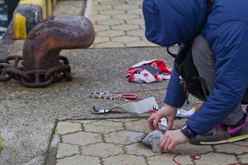 <p>A fisherman measures a catch from right along the pier</p>