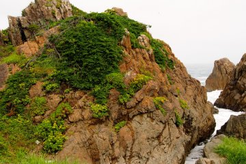 <p>Red rocks against blue and grey landscape</p>