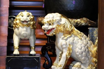 <p>Close-up of two statues of white Chinese lions. One's mouth is closed (not in this photo) and the other's mouth is open, which represents the beginning and the end of all things</p>
