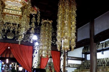 <p>Buddhist gold ornaments hanging from high ceiling</p>