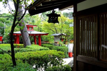 <p>A metal lantern hangs from the corner of a shrine building &nbsp;</p>